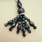 Close-up of faceted black beads and dangling strands on latkan tassel TSL-1233