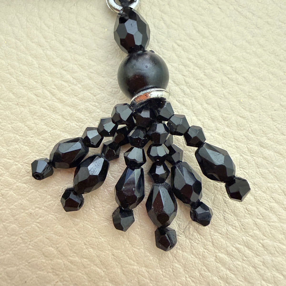 Close-up of faceted black beads and dangling strands on latkan tassel TSL-1233