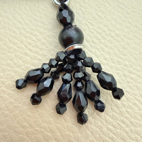 Close-up of faceted black beads and dangling strands on latkan tassel TSL-1233