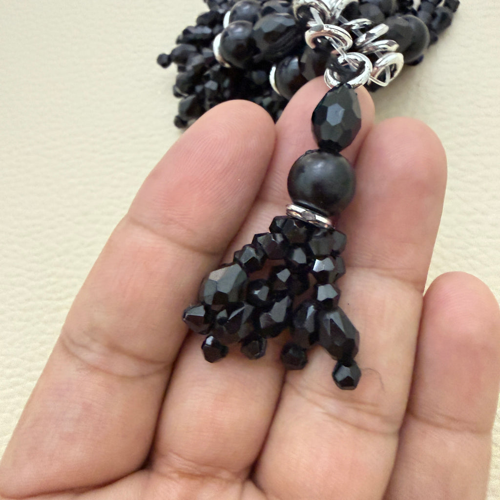 Black beaded tassels arranged in a circle; product sold as a pack of two