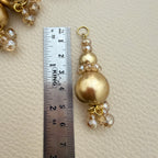 Detail of gold-tone round beads and dangling champagne-coloured beads on latkan tassel